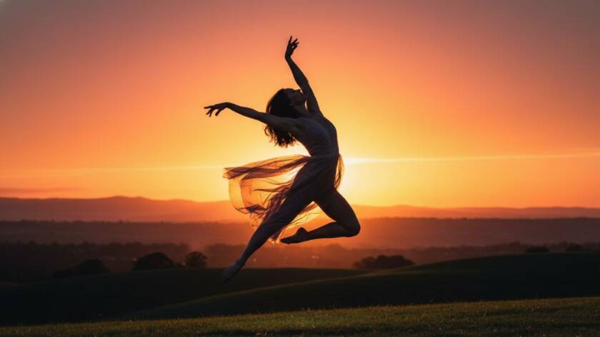 An expressive dance photography Croydon Victoria shot featuring a female dancer in mid-air, silhouetted against a golden hour sunset over Croydon's hills, capturing a moment of powerful artistic flight with dramatic lighting.