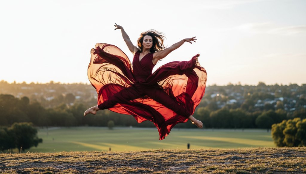 An expressive dance photography session in Forest Hill, Victoria, showcasing a dancer mid-leap, silhouetted against a dramatic sunset sky over a slightly blurred Forest Hill parkland, professional and cinematic.