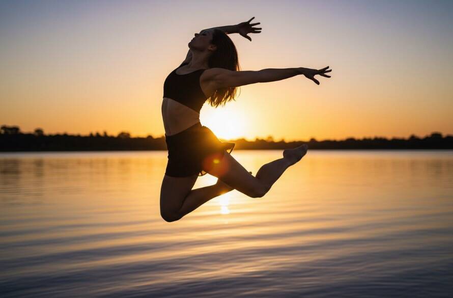 An epic moment in expressive Sandhurst contemporary dance photography, showing a female dancer suspended mid-air in a dramatic leap over the shimmering waters of Sandhurst Lake, back lit by a golden sunset, capturing raw emotion and dynamic form.