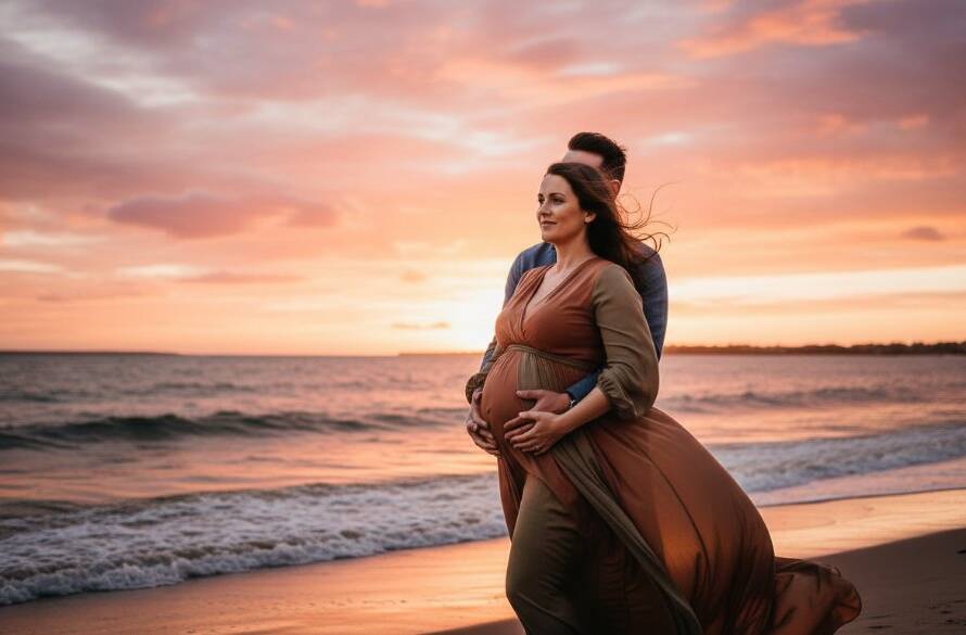 A pregnant woman in an elegant flowing gown stands silhouetted against a dramatic sunset over Port Phillip Bay, showcasing a Frankston North maternity photoshoot stunning Bay views, capturing an epic, emotional moment.