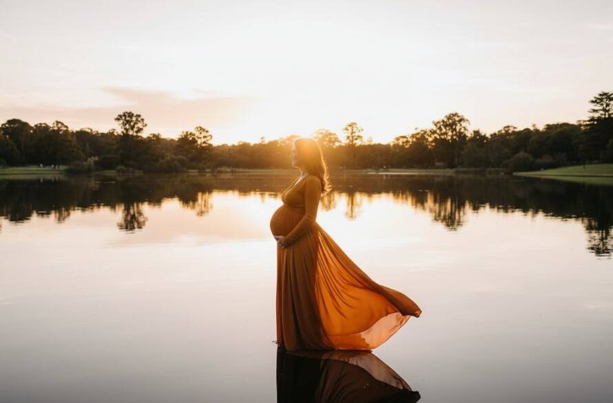 A glowing maternity photoshoot Glen Waverley scene featuring an expectant mother in a flowing gown at sunset, silhouetted against a serene natural backdrop, capturing an epic moment of serene anticipation and beauty.