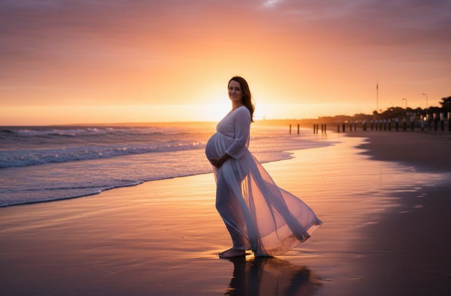 A pregnant woman, bathed in the soft glow of golden hour maternity photography Geelong, stands gracefully on a windswept beach at sunset, her silhouette framed by the dramatic sky, embodying an epic moment of anticipation.