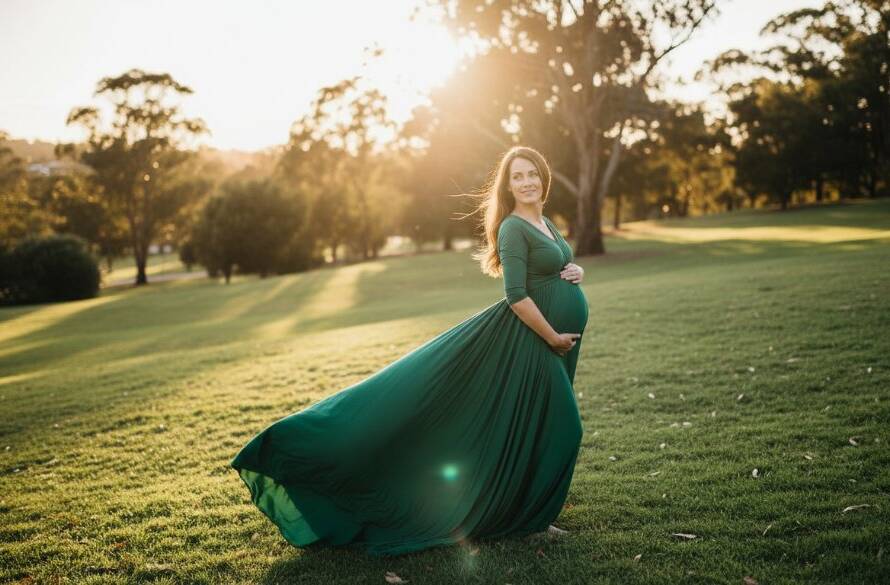 A glowing expectant mother bathed in soft golden hour light, posing gracefully in a lush park in Caulfield South for stunning golden hour maternity portraits. Her flowing dress catches the breeze as she cradles her bump, radiating joy and anticipation, with a dreamy bokeh background.