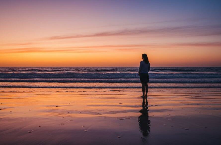 A captivating 'epic moment' fine art photograph showing a silhouetted person standing contemplatively on a Hampton East beach at sunset, with dramatic golden light reflecting on the wet sand, embodying Hampton East fine art photography capturing coastal elegance.