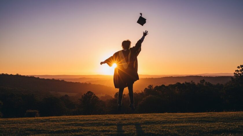 A proud graduate, cap mid-air, silhouetted against a golden sunset over the rolling hills of Hepburn Springs, celebrating their Hepburn Springs graduation photography capturing academic success Victoria with immense joy and triumph.