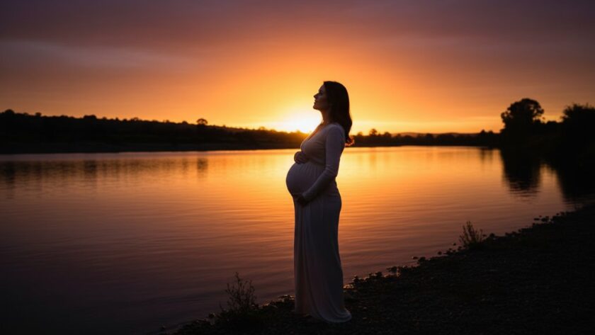 An ethereal Highton Victoria artistic maternity photography Geelong portrait featuring a radiant pregnant woman silhouetted against a dramatic sunset over the Barwon River, professionally lit to highlight her graceful form and the serene landscape.