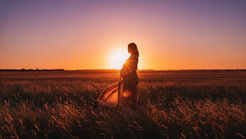 An expectant mother silhouetted against a dramatic, fiery sunset over the Huntly plains, beautifully capturing the essence of Huntly Victoria maternity photography with stunning sunsets, showcasing an epic moment of natural beauty and maternal grace.