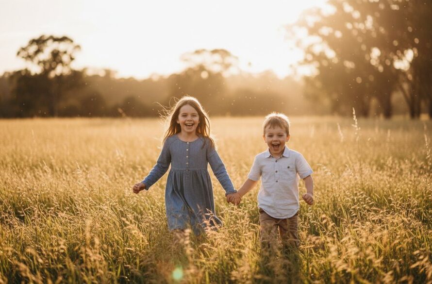 An epic moment from joyful Herne Hill kids photo adventures, featuring two beaming children in mid-run through a sunlit field, their laughter echoing, captured with beautiful golden hour light filtering through trees in Herne Hill, Victoria, showcasing pure childhood joy.