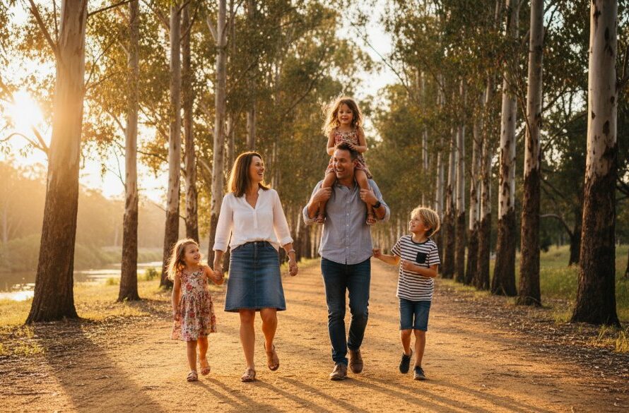 A vibrant Kialla family photography capturing genuine moments of joy, with parents playfully lifting their child against a warm, golden hour backdrop near the Goulburn River, showcasing laughter and connection in a beautifully lit, professional shot.