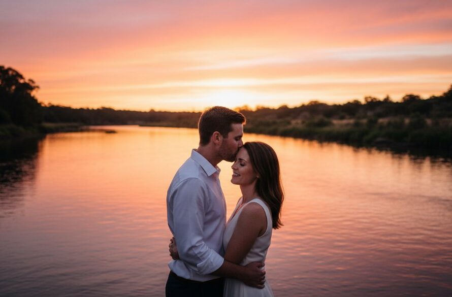 An enchanting Kialla pre-wedding photography Goulburn River sunset moment, featuring a couple embracing warmly as golden light bathes the scenic riverbank, creating a cinematic, professional wedding photo.