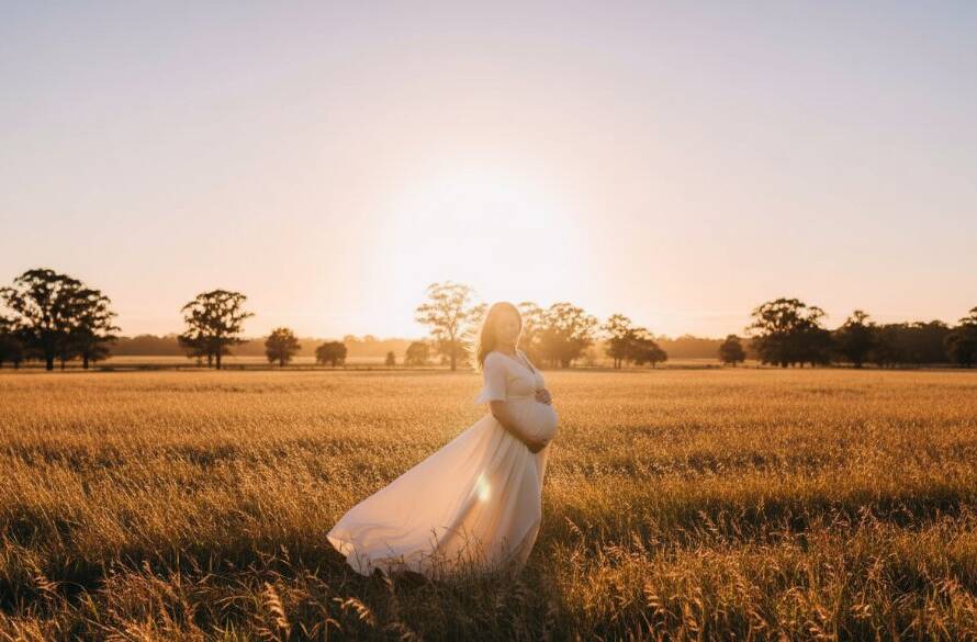 An emotionally radiant pregnant woman, elegantly posed amidst the lush, golden-hour glow of a Knoxfield park, capturing a Knoxfield maternity photography artistic outdoor portrait with dramatic lighting and professional colour grading.