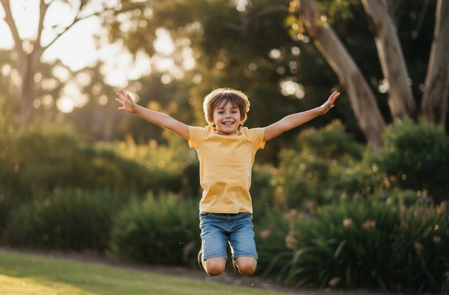 An epic moment of a child laughing joyfully, mid-jump, against the vibrant green backdrop of the Leongatha Hoddle Street park at sunset, captured with professional dramatic lighting and warm colour grading, showcasing Leongatha kids photography capturing genuine joy.