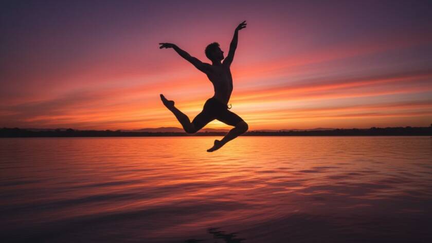 A powerful, wide-angle shot of a contemporary dancer mid-leap against a dramatic sunset backdrop over Lysterfield Lake, capturing the essence of Lysterfield dance photography for vibrant performances with cinematic lighting and a sense of artistic freedom.