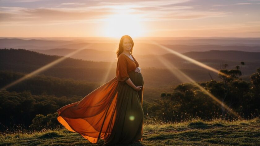A glowing expectant mother, silhouetted against a dramatic sunset over the rolling hills of the Macedon Ranges, lovingly cradles her baby bump in a stunning scene capturing Macedon Ranges bespoke maternity portraits with cinematic light.