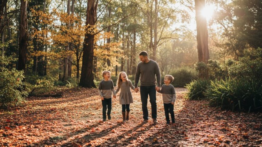 An emotional, candid moment captured: A family embracing amidst the stunning autumn foliage of the Macedon Ranges, showcasing genuine connection through Macedon Ranges genuine candid photography family stories, bathed in warm, golden hour light.