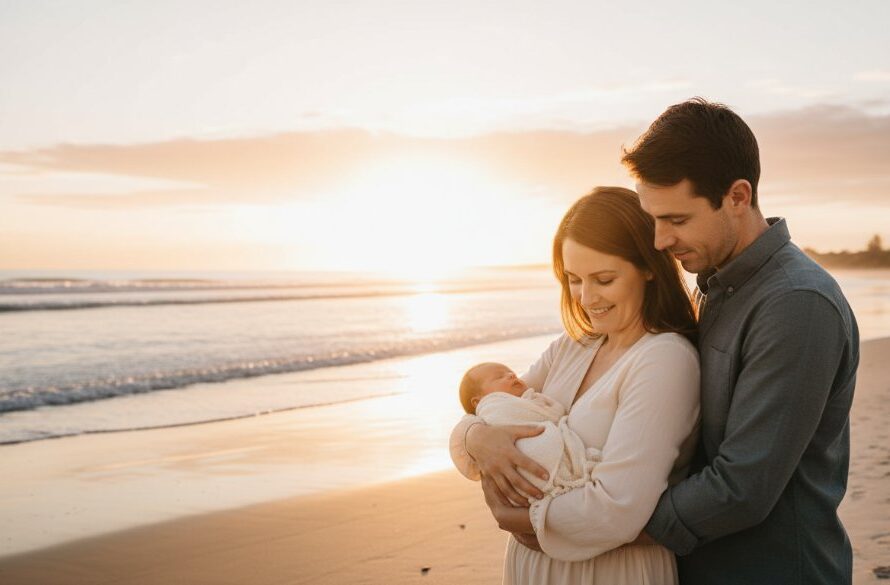 An emotional, professional photograph capturing a family with their newborn baby at sunrise on a Mallacoota beach, symbolizing their unique Mallacoota coastal newborn photoshoot experience, with dramatic golden light and gentle waves.