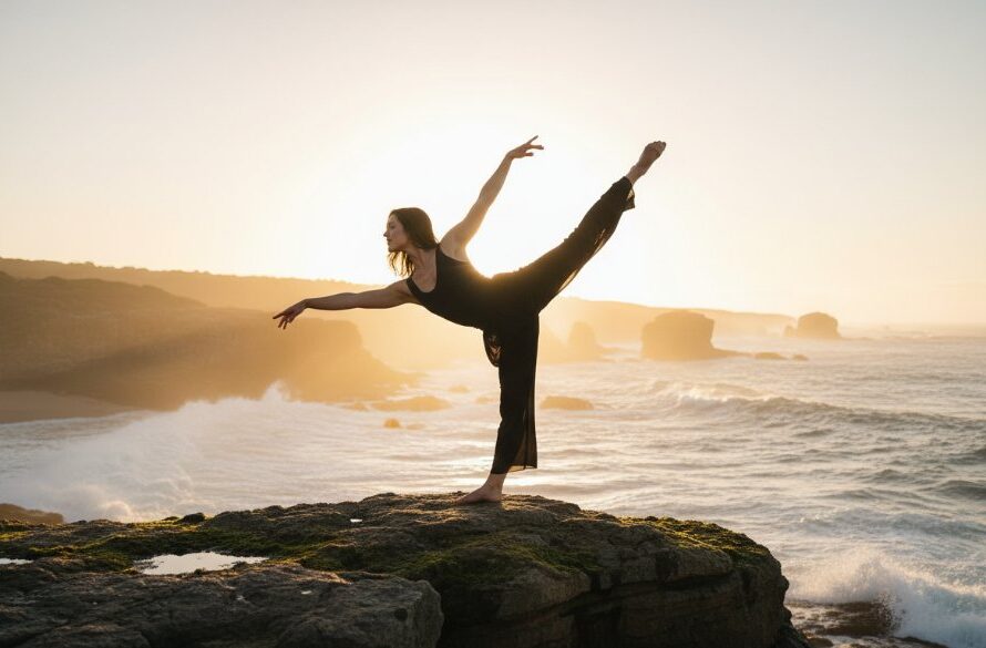 An exquisite dancer in mid-leap, silhouetted against a dramatic sunset over Mallacoota's rugged coastline, embodying the elegance of Mallacoota dance photography capturing coastal elegance.