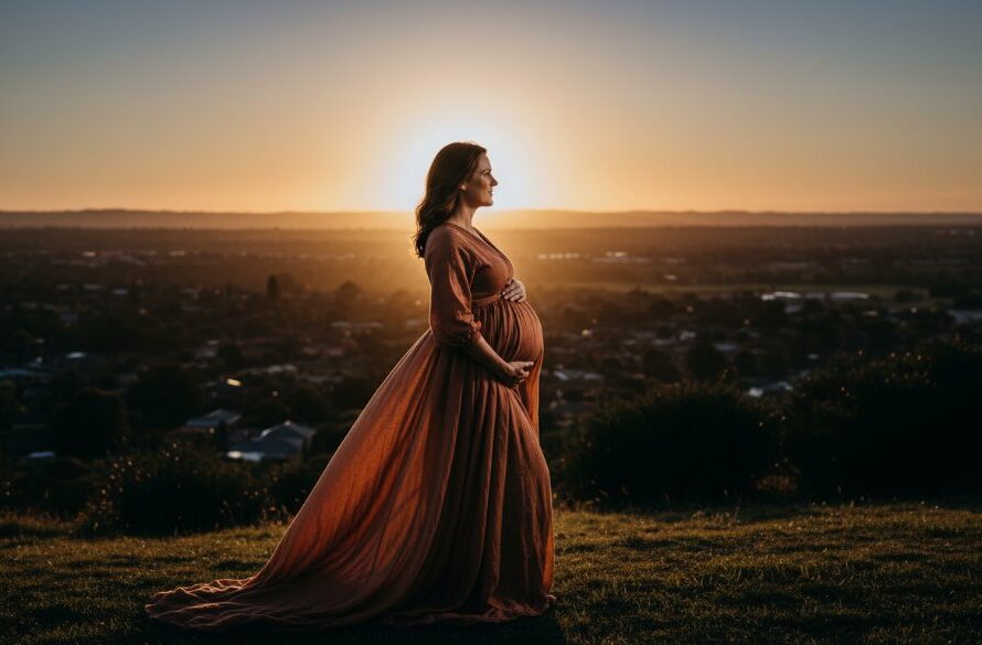 A stunning golden hour portrait of an expectant mother in a flowing gown, silhouetted against a dramatic Manifold Heights landscape, embodying the artistic spirit of Manifold Heights artistic maternity photos Victoria, with warm, cinematic lighting and a serene expression.
