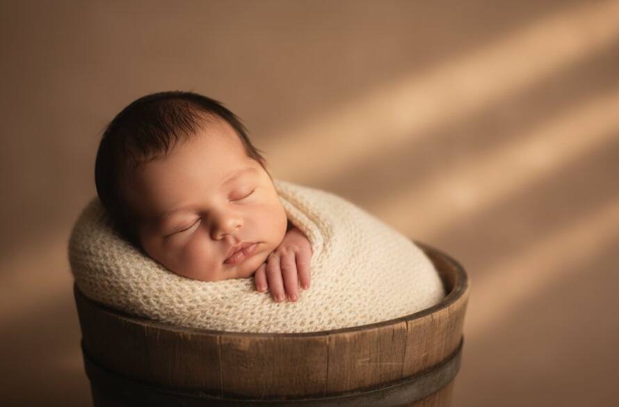 A close-up, warm-toned portrait from Manor Lakes newborn photography capturing tiny details, showing a sleeping baby's tiny hand gently grasping their parent's finger, bathed in soft, ethereal natural light, with shallow depth of field, evoking a sense of pure love and connection, set against a subtle, elegant backdrop.