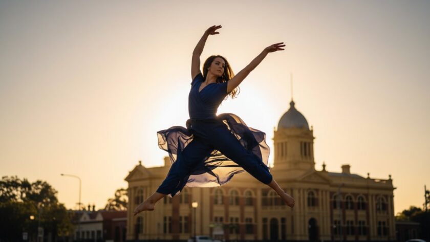 Dynamic wide shot of a ballet dancer mid-leap at sunset in Maryborough, Victoria, perfectly showcasing Maryborough Victoria dance photography capturing graceful motion, with the historic streetscape softly blurred in the background, dramatic golden hour lighting, professional colour grading.