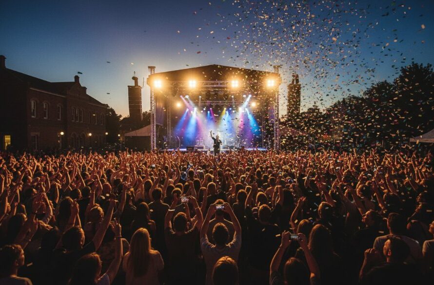 A high-angle, cinematic shot capturing the vibrant energy of a local community festival in Sale, Victoria, with diverse crowds enjoying live music under dramatic twilight skies, perfectly showcasing memorable event photography Sale Gippsland.