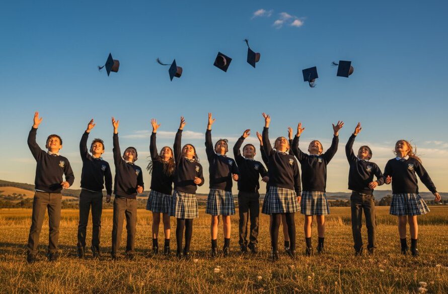 An inspiring, low-angle shot of a group of excited primary school students from Miners Rest, captured by professional Miners Rest School Photography capturing student milestones, celebrating their graduation in a sun-drenched schoolyard, with the iconic Miners Rest landscape subtly in the background, showcasing pure joy and achievement. Dramatic lighting highlights their faces, expertly color graded for a vibrant, professional finish.