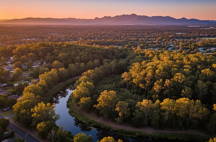 Dramatic aerial view captured by a drone in Mitcham Victoria drone photography breathtaking aerial views, showing the lush green canopy of Mitcham Reserve at golden hour with distant Dandenong Ranges, creating an epic moment of natural beauty.