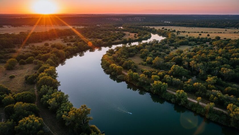 Dramatic aerial view of the Goulburn River winding through lush Mooroopna riverbend drone photography landscapes at sunset, golden light illuminating the water and dense bushland, capturing an epic moment of natural beauty.