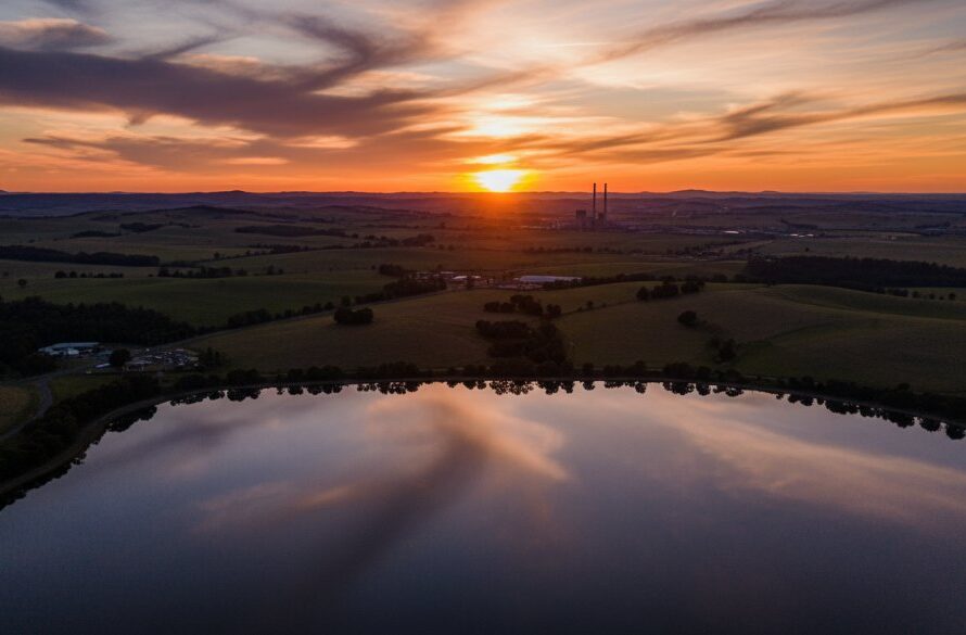 Dramatic aerial shot capturing the stunning Morwell aerial landscape drone photography, showcasing a vibrant sunset over the Gippsland plain with the shimmering Morwell Lake and distant rolling hills, professionally colour-graded for an epic, awe-inspiring moment.