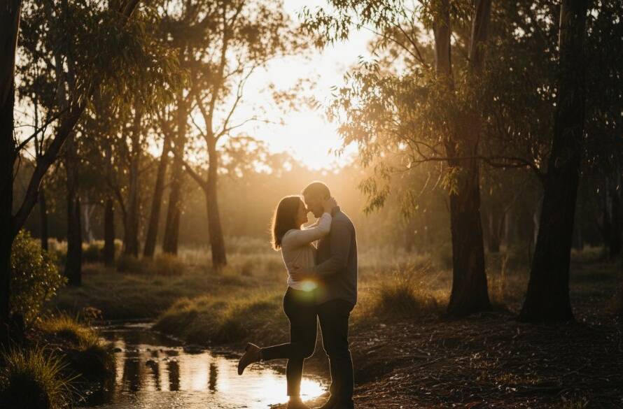 A newly engaged couple sharing a tender, epic moment at sunset, framed by lush greenery and historical architecture in one of Mount Waverley picturesque engagement photoshoot locations, captured with dramatic lighting.