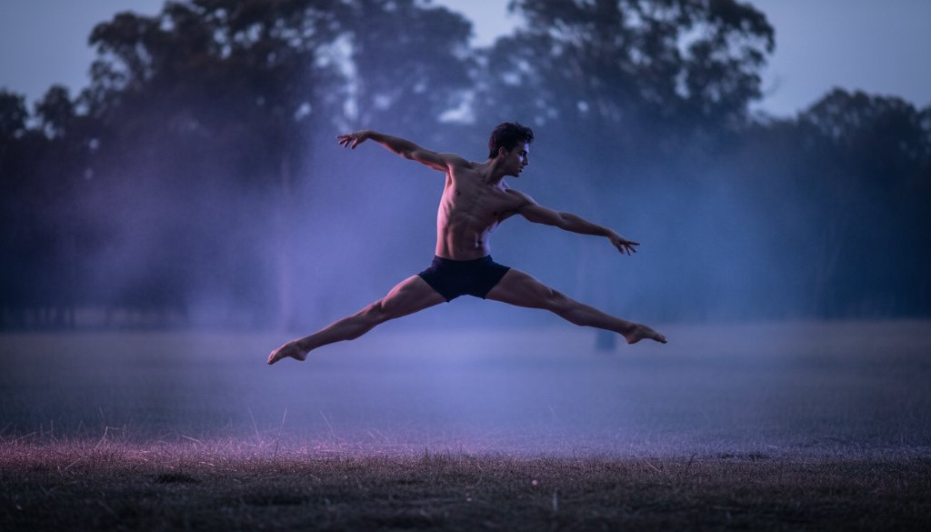 A male dancer captured mid-air in an awe-inspiring leap during a Narre Warren North dynamic dance photography session, with dramatic backlighting silhouetting his form against a misty, ethereal backdrop, conveying raw power and grace.