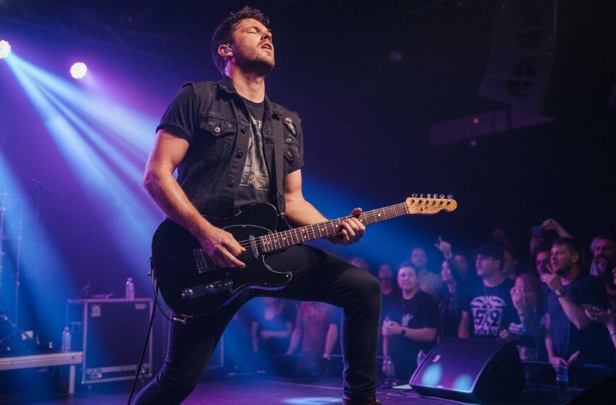 An epic moment of a lead singer bathed in dramatic purple and blue stage lights, guitar raised in triumph, capturing the raw energy and excitement of Newport Victoria Live Gig Photography Expertise.