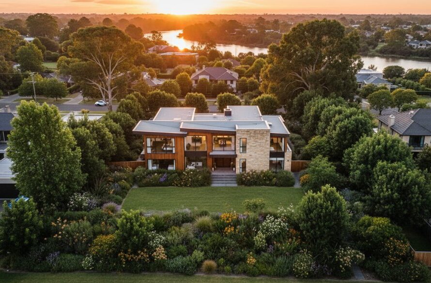 An epic moment captured by Newtown Victoria drone photography for real estate elevation, showcasing a luxurious modern home bathed in golden hour light, with the Barwon River meandering in the background and vibrant, lush gardens in the foreground, professional colour grading.