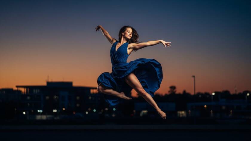A breathtaking, professionally captured Oakleigh East dance photography dynamic shots showing a dancer mid-leap against a softly blurred, vibrant backdrop, bathed in dramatic stage lighting, evoking raw power and grace.