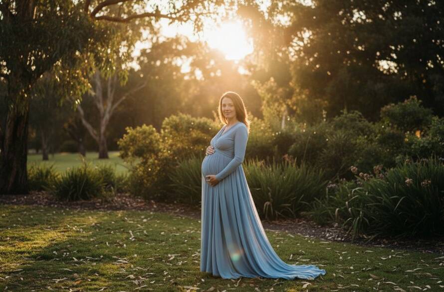 A serene outdoor Oakleigh South maternity photoshoot capturing glowing beauty, featuring a pregnant woman in a flowing gown at sunset, silhouetted against a golden sky in a lush Oakleigh South park, evoking a sense of calm and anticipation. Professional, cinematic composition.