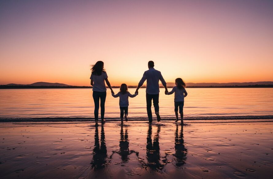 An Orbost family photography authentic East Gippsland memories scene, showing a family silhouetted against a dramatic sunset over the Snowy River estuary, laughing and running on a beach, professionally colour-graded with warm, golden light and cinematic composition.