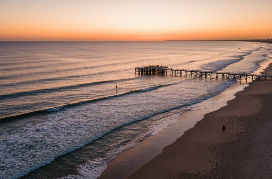 An epic moment of a drone capturing Parkdale coastal drone photography stunning aerial views, featuring golden hour light illuminating the serene beach, distant pier, and sparkling azure waters from a high vantage point.