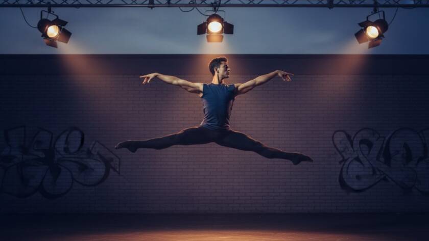 An electrifying 'epic moment' photograph capturing a dancer mid-air, bathed in dramatic stage lighting, showcasing passionate Mulgrave dance photography vibrant artist portraits. The dancer's powerful leap is frozen in time against a blurred urban Mulgrave backdrop at dusk, emphasizing raw emotion and athletic grace.