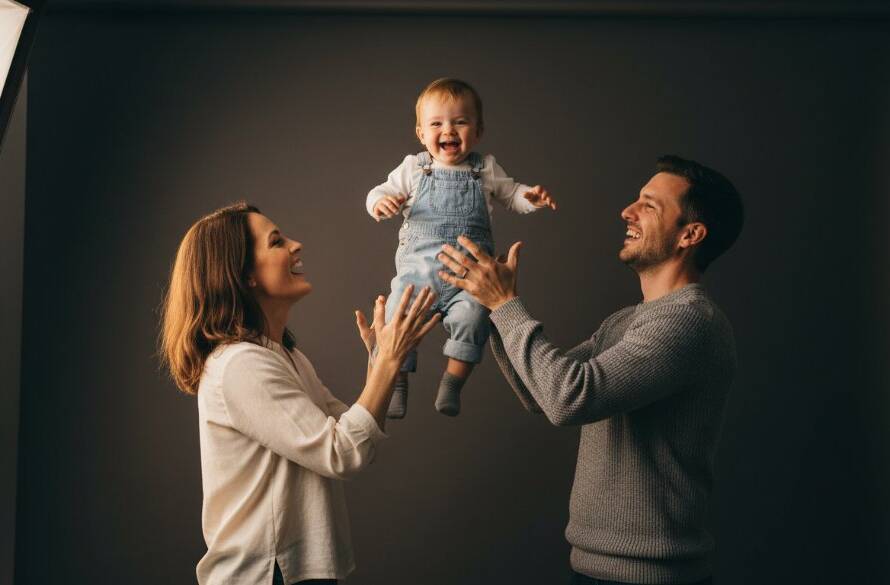 A striking close-up of a joyful family captured during their premier studio photography experience Chelsea Heights, showcasing genuine connection with soft, dramatic lighting, celebrating an epic moment of togetherness.