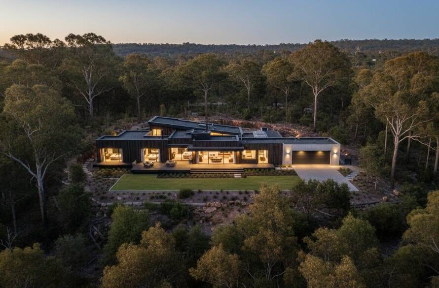 A drone's eye view capturing premium Warrandyte South real estate photography services at sunset, showcasing a modern luxury home nestled amongst lush gum trees, with golden light illuminating the property and surrounding natural landscape.