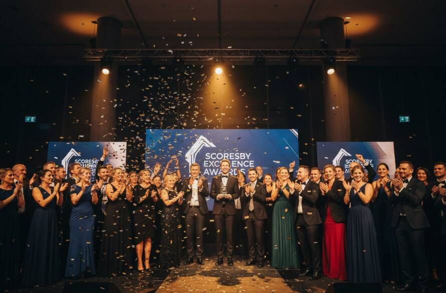 An epic moment captured by professional event photography Scoresby Victoria, featuring a group of jubilant attendees cheering at a corporate gala dinner in a beautifully lit Scoresby venue, celebrating a significant achievement.