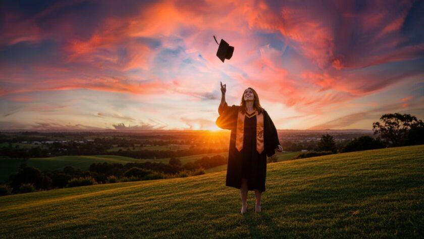 A joyous graduate in a cap and gown, framed by the vibrant Drouin Botanic Park, tossing their mortarboard high against a dramatic sunset, capturing their professional graduation photography Drouin Victoria epic moment.