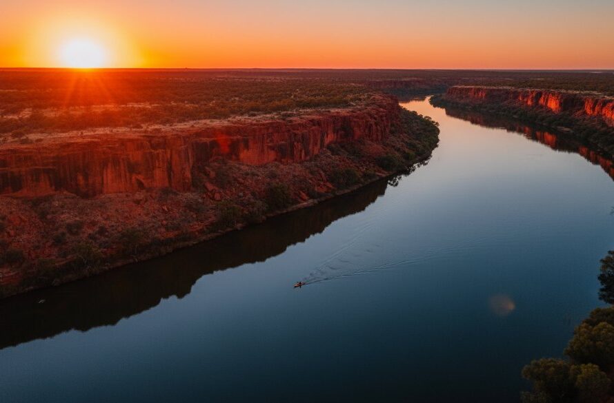 An epic aerial shot of the tranquil Murray River at sunset near Red Cliffs, Victoria, showcasing the vibrant red cliffs and the winding river under a dramatic, colourful sky, captured with Red Cliffs Victoria drone photography, evoking a sense of peaceful grandeur.
