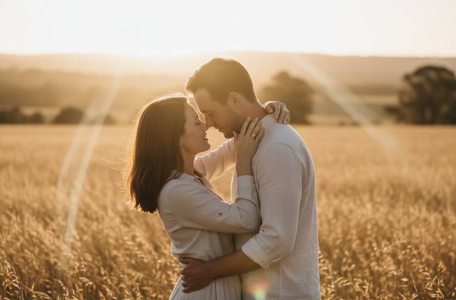 An epic moment captured: A young couple embraces passionately amidst the golden hour glow in a picturesque Beaconsfield open field, showcasing romantic Beaconsfield engagement photography unique locations with dramatic, cinematic lighting and professional color grading.