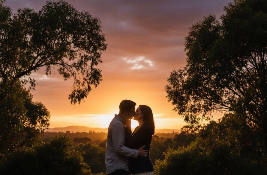 An emotionally resonant and visually stunning professional photograph capturing an epic moment during a romantic Heathmont engagement photoshoot Victoria, with a couple silhouetted against a dramatic sunset over Heathmont Park, showcasing their embrace with warm, cinematic lighting and professional colour grading.