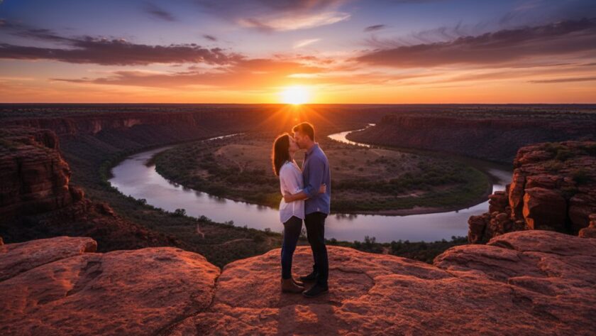 An epic, wide-angle shot capturing a couple sharing a tender kiss at sunset amidst the iconic red cliffs of Red Cliffs, Victoria, silhouetted against a vibrant orange and purple sky, showcasing romantic Red Cliffs sunset engagement photography at its finest.