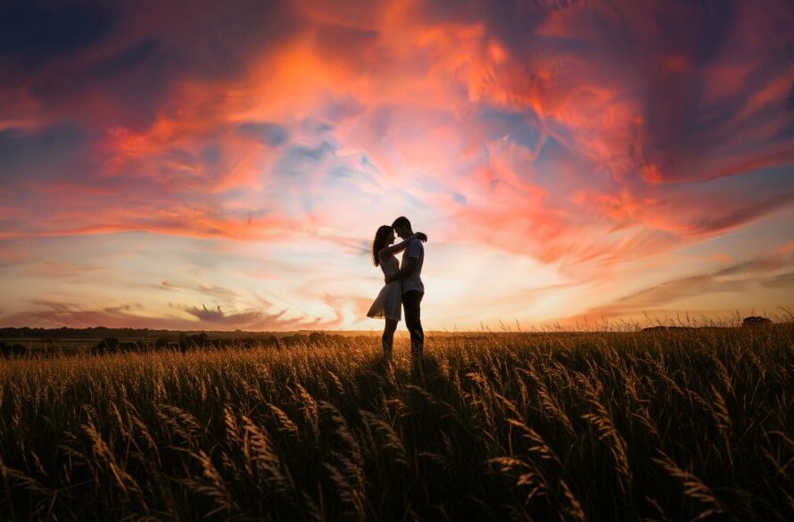 A couple embracing intimately during their 'Romantic Wallan countryside engagement session', silhouetted against a dramatic golden hour sky over rolling hills, capturing an epic, emotion-filled moment of their love story.