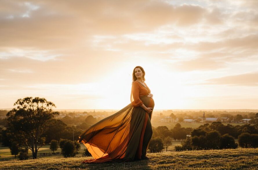 An awe-inspiring image from a Sebastopol Victoria maternity photoshoot capturing glowing mum-to-be standing gracefully against a dramatic, sunset-lit landscape, her silhouette framed by golden light, evoking peace and strength.