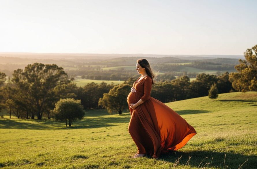 An expectant mother, illuminated by golden hour light amidst the lush Daylesford countryside, captures a serene Daylesford maternity photoshoot Victoria's scenic beauty, showcasing an epic moment of natural elegance and anticipation.