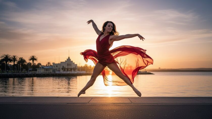 A professional photograph of a dancer performing an elegant leap against the vibrant, soft-focus backdrop of the Geelong Waterfront at sunset, perfectly capturing South Geelong dynamic dance photography for performing arts with dramatic backlighting and a sense of graceful power.